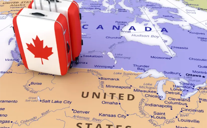 A photo of a map, depicting the Canada-United States border, and suitcases.